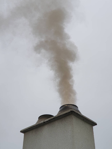 Chimney producing dirty polluting smoke in urban area on cloudy day. Environmental issues include polluting the air with toxic gases. - Photo, Image