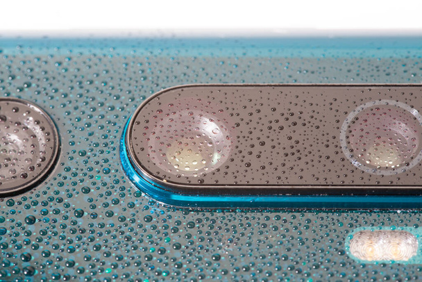 aurora lente de câmera de telefone pérola verde coberto com pequenas gotas de água close-up com foco seletivo e desfoque
 - Foto, Imagem