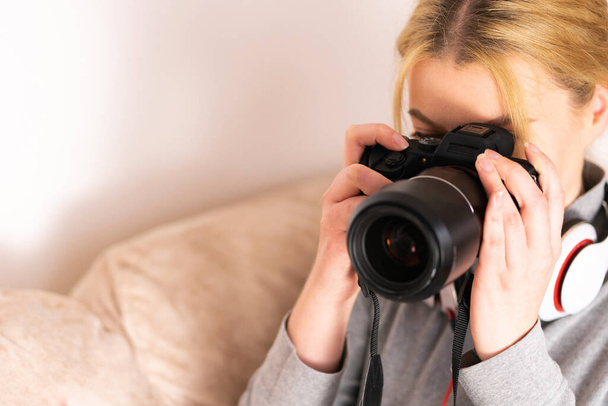 Jeune femme utilisant un appareil photo dslr sans miroir pendant les vacances d'été en prenant des photos pendant les vacances à la salle d'hôtel touristique - Photo, image