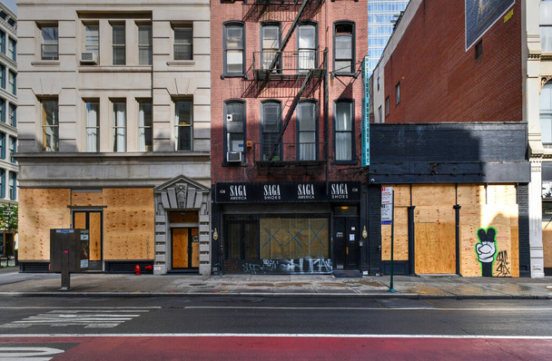 Nowy Jork, Nowy Jork - 11 czerwca 2020: Sklep zamknięty podczas pandemii COVID-19, z oknami z deskami do ochrony przed kradzieżą w wyniku protestów przeciwko brutalności policji. - Zdjęcie, obraz