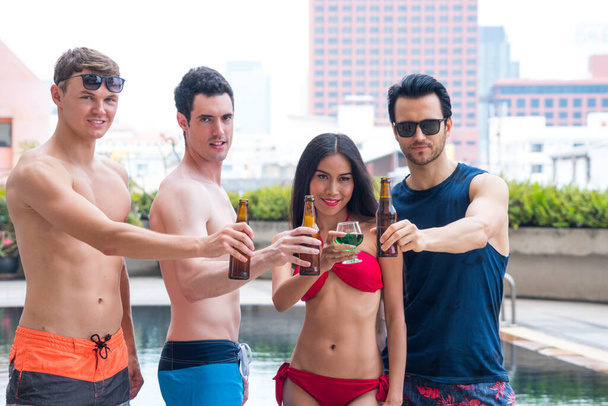 Group Of Friends Having Party In Pool Drinking beverage exotic cocktails and beer drink. - Photo, Image