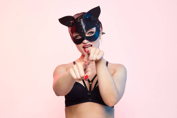beautiful girl in a cat mask. playfully posing in front of the camera. - Photo, image