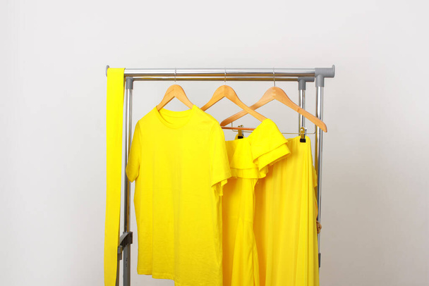 Bright yellow summer clothes hanging on the rail. A cheerful, positive female outfit. Clothing for the holiday, relaxation at sea, summer walks. - Zdjęcie, obraz
