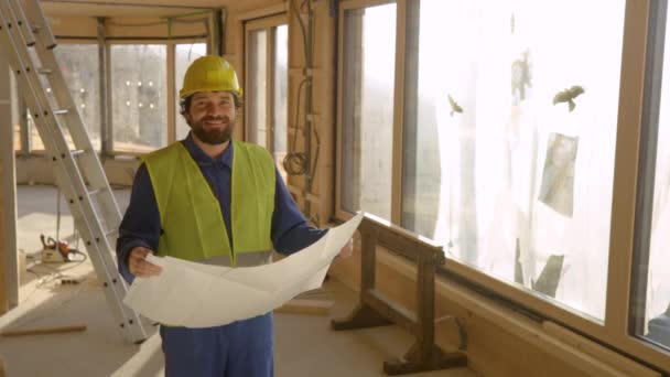 レンズフレア:建設現場のマネージャーは床の計画を保持しながら笑顔. - 映像、動画