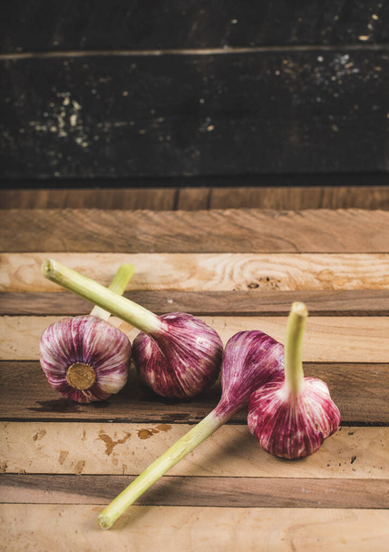 Fresh small garlics on a black wooden background - Zdjęcie, obraz