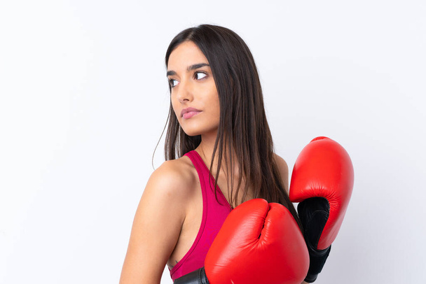 Young sport brunette woman over isolated white background with boxing gloves - Photo, Image