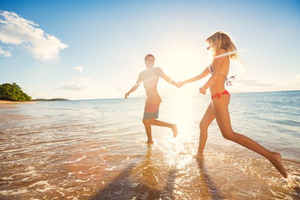 Happy Couple on Tropical Beach at Sunset - Photo, image