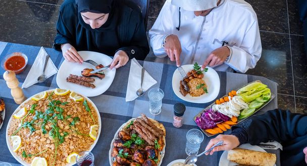 ラマダーン月で一緒に食事を楽しむ幸せなアラビア人ムスリム家族 - 写真・画像