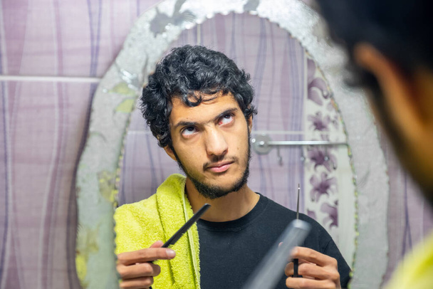Árabe musulmán hombre cortando su propio pelo por sí mismo
 - Foto, Imagen
