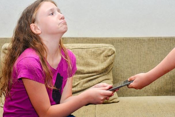 Девочка-подросток, зависимая от социальных сетей, не хочет давать своим родителям смартфон
 - Фото, изображение