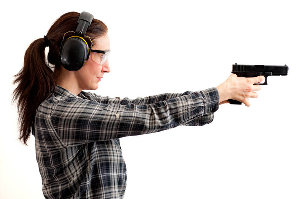 二番目の改正は、銃を目指している女性と射撃場の概念で銃の自己防衛と使用し、クリッピングパスが含まれている白に隔離された保護具を身に着けている間に撮影する準備ができて - 写真・画像