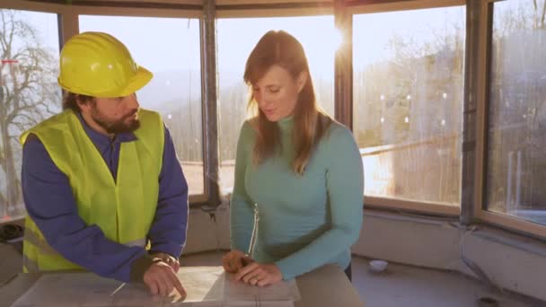 LENS FLARE: Woman shakes hands with engineer after discussing the floor plans - Footage, Video