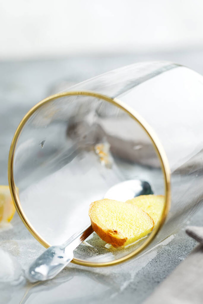 Освіжаючий імбир у склянці з краплями води на мармуровому сірому столі
. - Фото, зображення