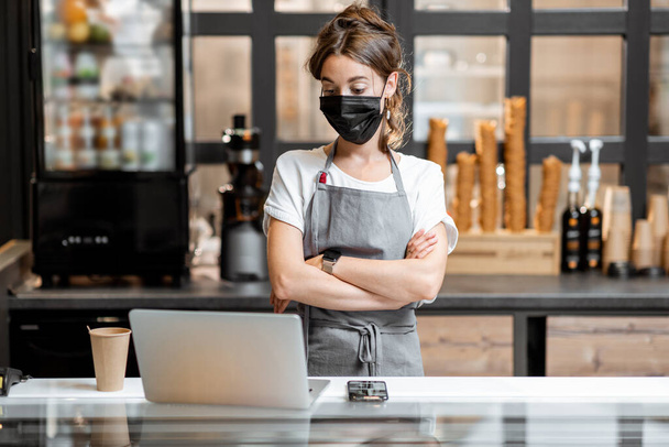 Saleswoman en masque médical dans un café ou un petit magasin - Photo, image