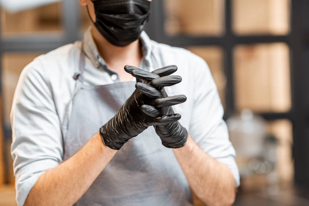 Verkäufer desinfiziert Hände im Geschäft oder Café - Foto, Bild
