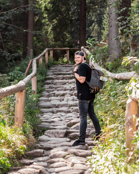 człowiek z plecakiem wędrówki w lesie przez kamienny szlak koncepcja podróży - Zdjęcie, obraz