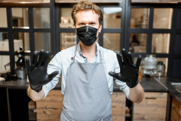 Salesman in protective wear in the cafe during a pandemic - Φωτογραφία, εικόνα