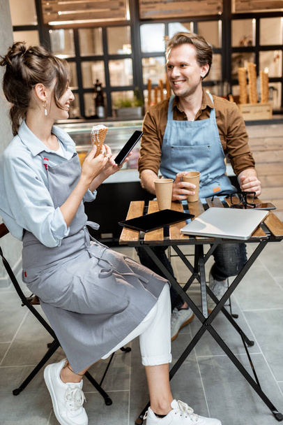 Couple of a cheerful cafe workers indoors - Photo, Image