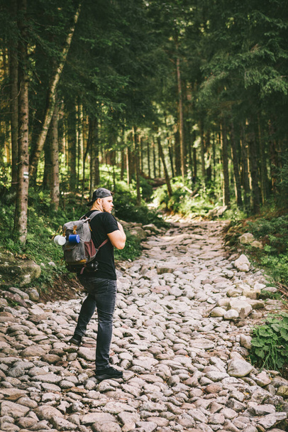 férfi hátizsák túrázás az erdőben kő út utazás koncepció - Fotó, kép
