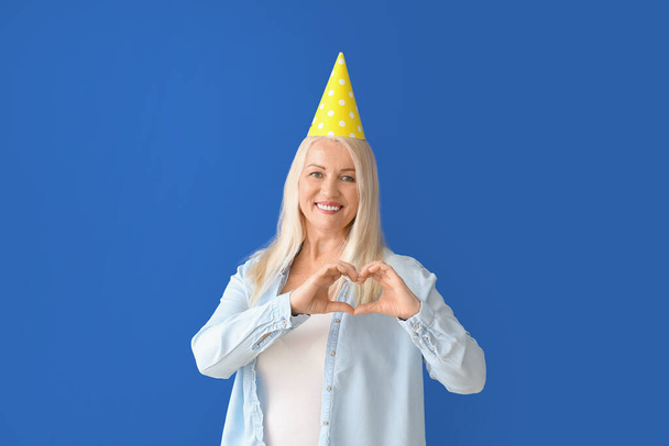 Mature woman celebrating Birthday on color background - Zdjęcie, obraz