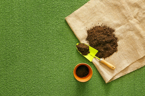 Lopata pro zahradničení s půdou a hrncem na barevném pozadí - Fotografie, Obrázek
