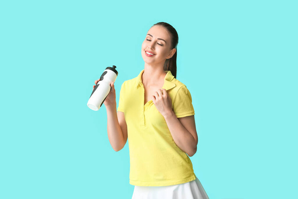 Sporty young woman with bottle of water on color background - Fotografie, Obrázek