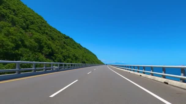 Vezetés a hegyi és tengerparti autópályán kék ég háttér. POV - Felvétel, videó