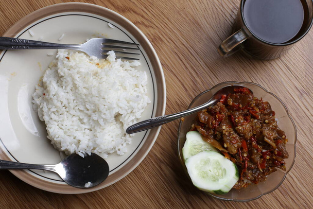ヨガジャカルタ伝統のオセン・オセン・メルコン肉と米を木のテーブルの上で - 写真・画像