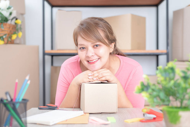 Selling online work from home. Women business owner working at home with packing box on the workplace - online shopping - Foto, afbeelding
