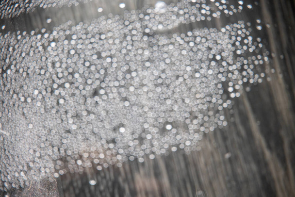 out of focus grijs water druppels in close-up creëren bokeh achtergrond - Foto, afbeelding