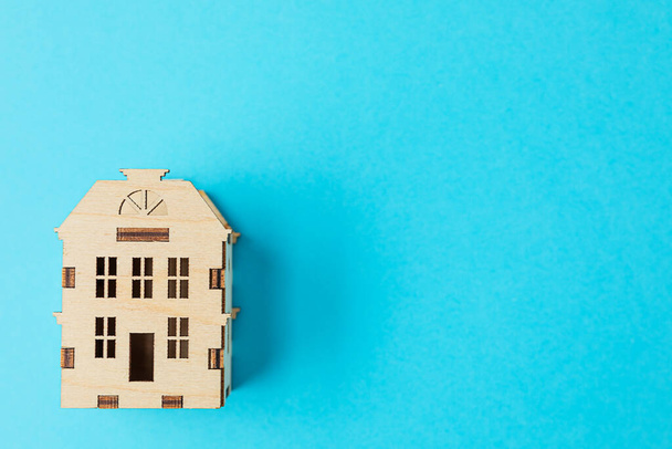 figura drewnianego domu na niebieskim tle. przestrzeń kopiowania. - Zdjęcie, obraz