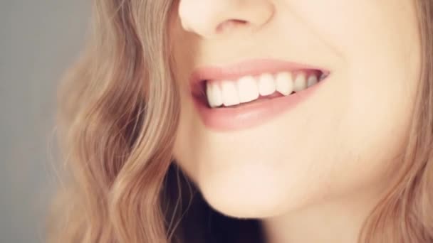 Piękny uśmiech młodej kobiety z perfekcyjnie zdrowymi białymi zębami, zdrowiem i pięknem - Materiał filmowy, wideo