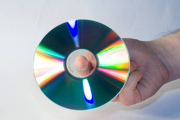 silberne CD-Scheibe in männlicher Hand auf weißem Hintergrund - Foto, Bild