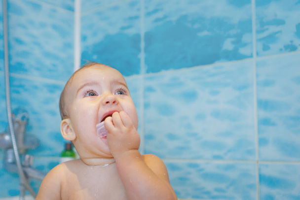 a little girl brushes her teeth in the bathroom. portrait of a child with a toothbrush - Foto, Imagem