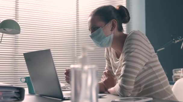Business woman with face mask having a video call in the office - Materiał filmowy, wideo