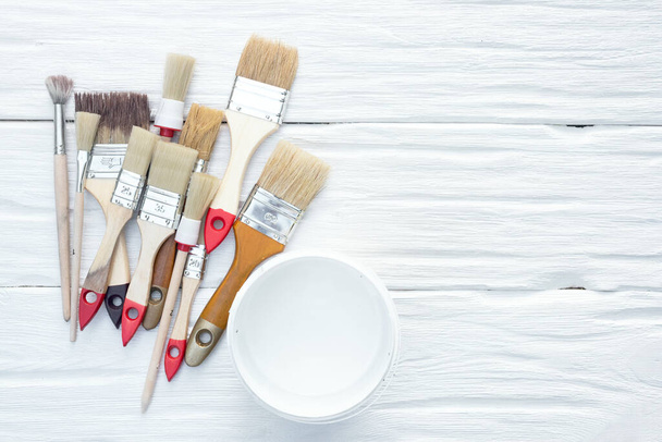 Paintbrushes and a cans of paint on a white board background with a copy space. - Foto, imagen