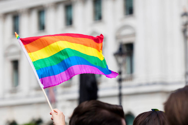 Gay pride, LGBTQ rainbow flags being waved in the air at a pride event - Фото, изображение
