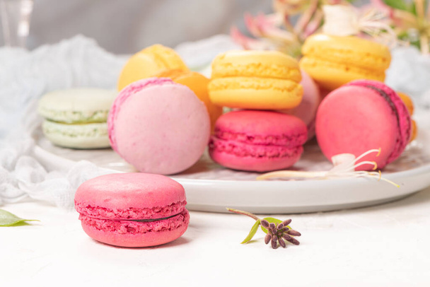 Renkli Fransız kurabiyeleri. Beyaz masa arkaplanında yasemin çiçekli kurabiyeler. Seçici odak - Fotoğraf, Görsel