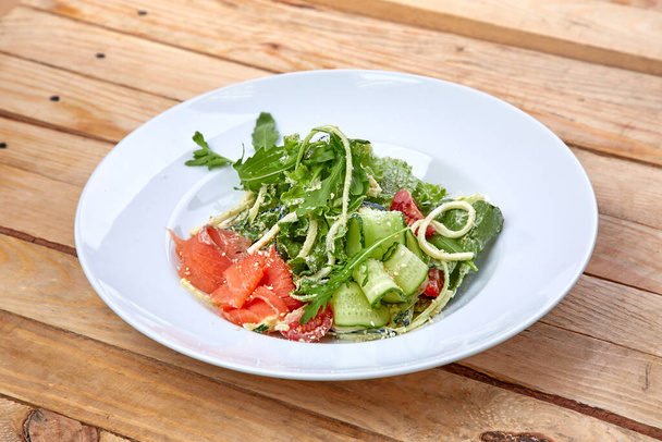 salmón salado con verduras frescas en plato blanco, vista cercana  - Foto, Imagen