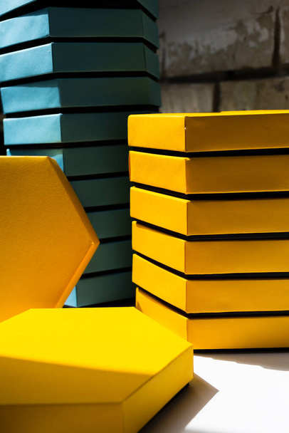 A close up beautiful blue and yellow hexagon boxes of present on the brick background. Place for text. side view. Mockup - Photo, Image