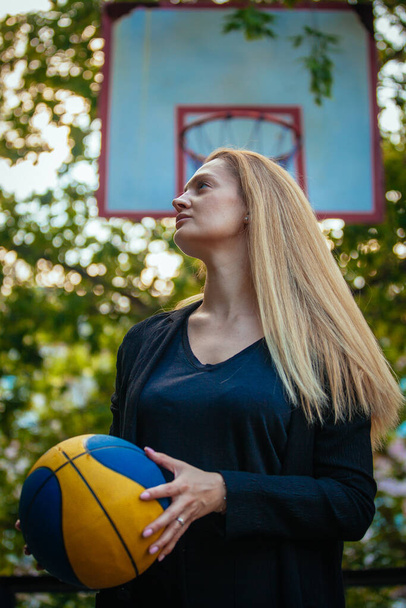 Νεαρή γυναίκα με μπάλα στο γήπεδο μπάσκετ κοινωνική  - Φωτογραφία, εικόνα
