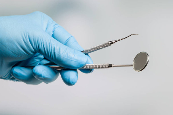 Zahnarzthand in blauen Handschuhen mit einem Satz zahnärztlicher Instrumente  - Foto, Bild