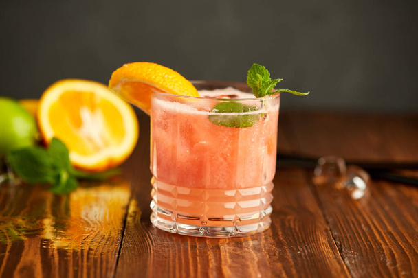 Grapefruit and orange smoothie coctail on grey wooden background. Refreshing drinks - Photo, image