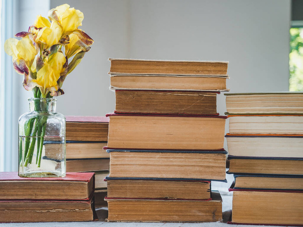 Stack of vintage books and a bouquet of beautiful flowers. Close-up, isolated background. Studio photo. Learning and Education Concept - Foto, Imagem