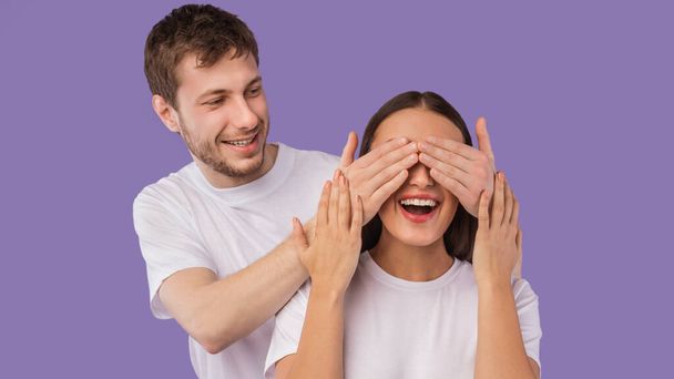 Guy covering his womans eyes from behind - Photo, Image