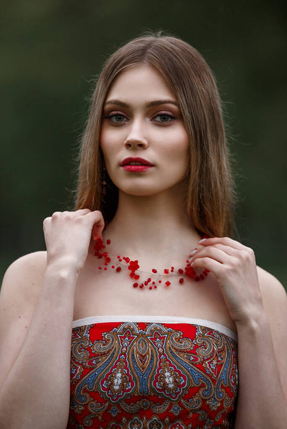 girl in a red dress in nature - Fotografie, Obrázek