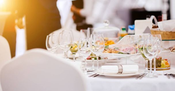 Prachtige feestelijke tafel van luxe borden, glazen en bestek geserveerd voor wijnproeverij. close up, wazige achtergrond. - Foto, afbeelding