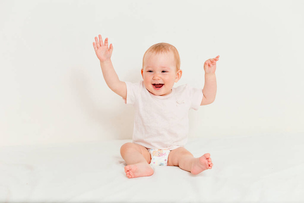 Cheerful little baby girl on a white background - Foto, imagen