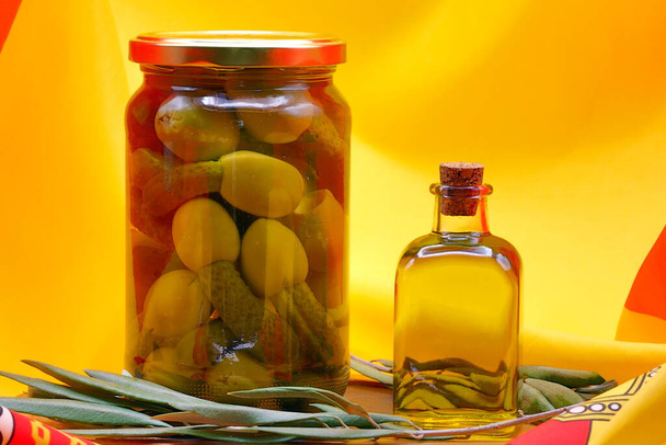 Products from Spain, glass jar with kimbo olives, boneless olives stuffed with pickles, raped olives, gherkin stuffed olives, glass bottle Extra Virgin olive oil, olive branches on the flag of Spain,  - Photo, Image