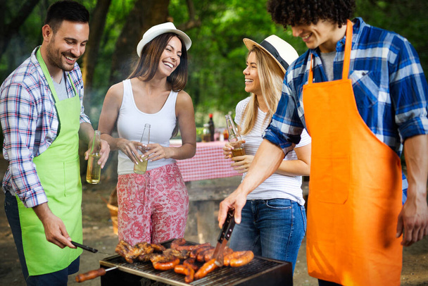 Group of friends having outdoor barbecue party and fun together - Foto, Bild